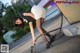 A woman in a skirt and high heels is bending over a gas pump.