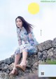 A woman sitting on top of a stone wall.