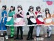 A group of young women dressed in maid outfits posing for a picture.