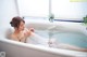 A woman sitting in a bathtub with her feet in the water.