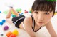 A young girl laying on the floor surrounded by colorful balls.