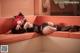 A woman with red hair laying on a couch.