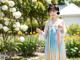 A woman in a colorful dress standing in a garden.